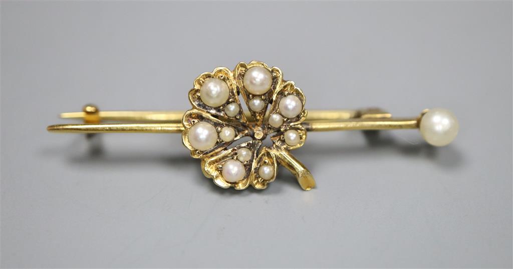A yellow metal and graduated seed pearl set flower head bar brooch, 42mm, gross 3.3 grams.